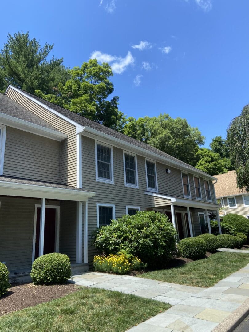 Tan siding house with walkway and green lawn.