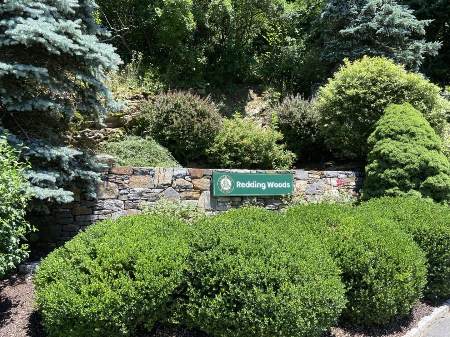 Stone wall with sign: Redding Woods.