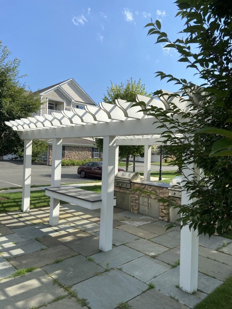 Outdoor kitchen with white pergola.