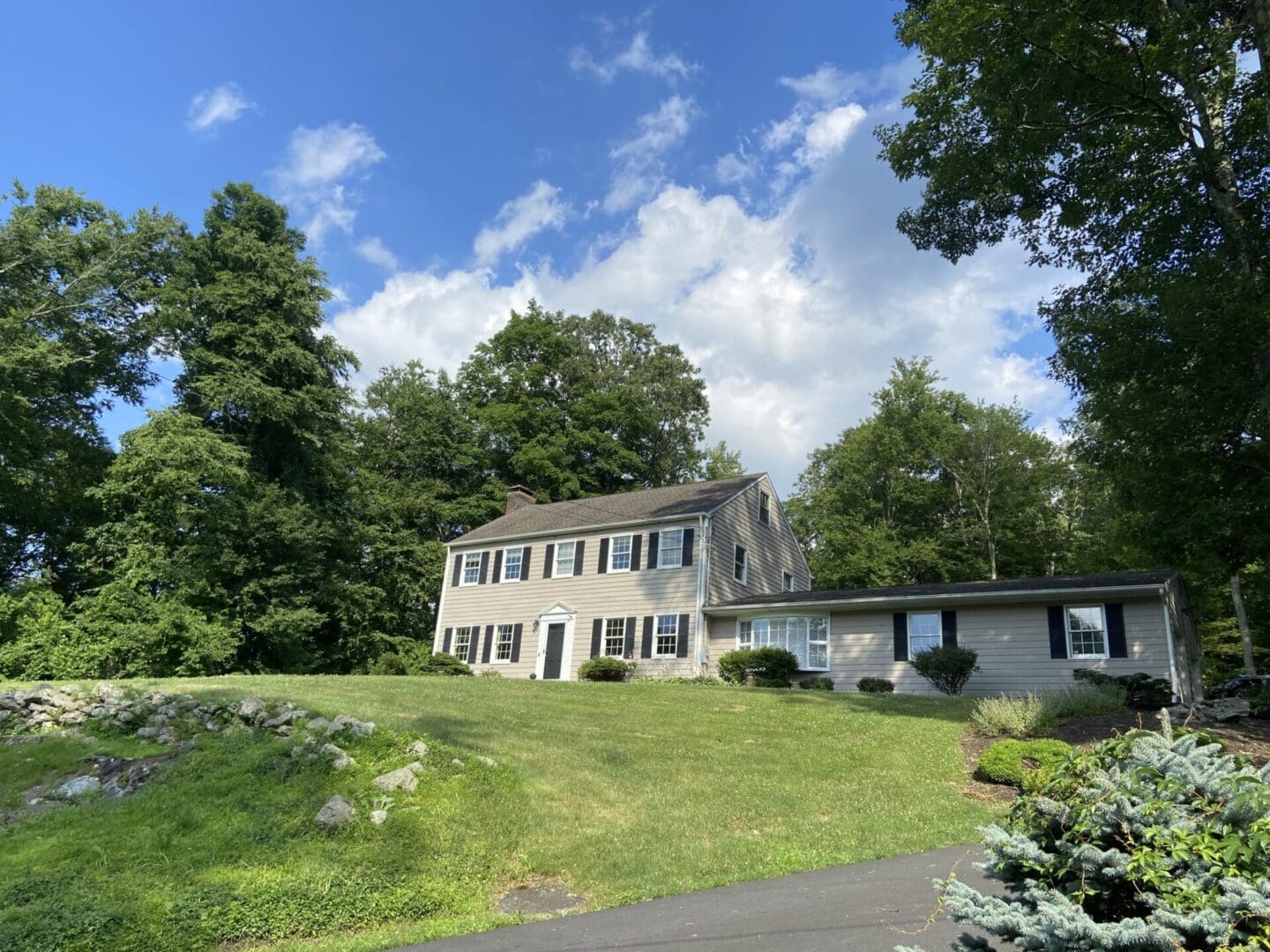 Two-story house with a lawn and trees.