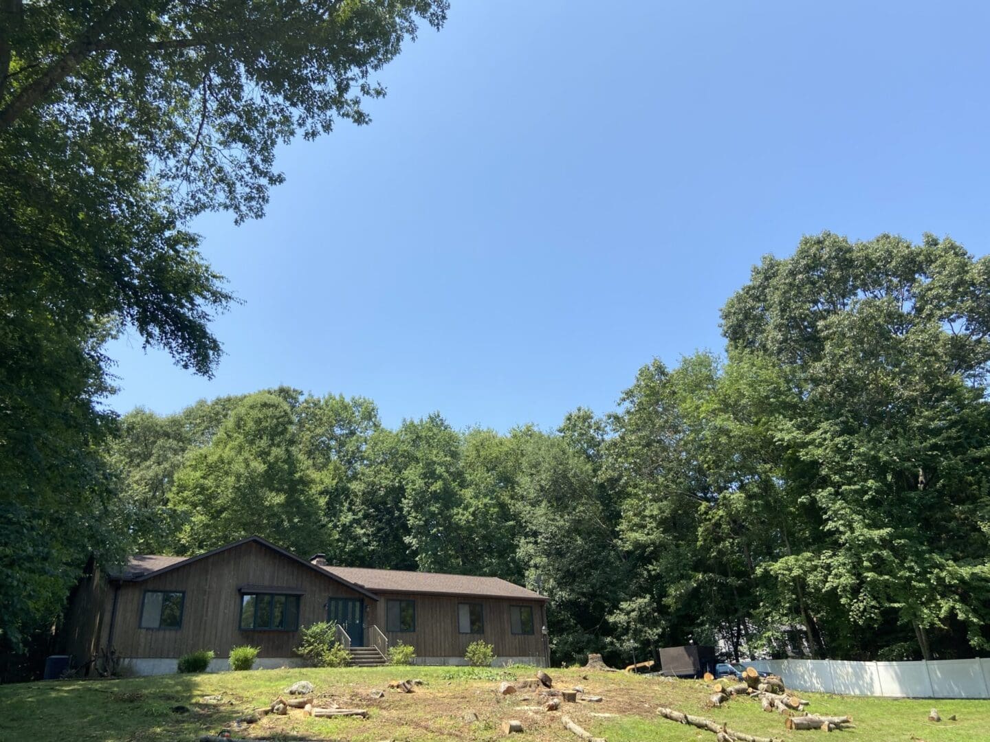 House in a wooded area with a blue sky.