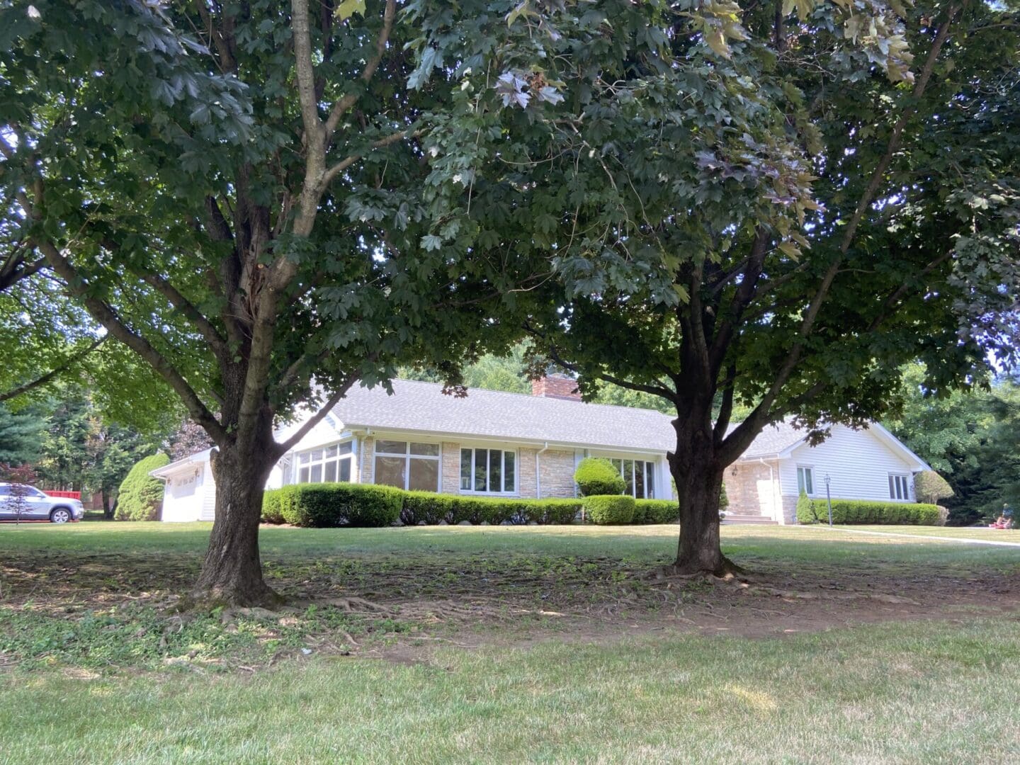 White house with green lawn and trees.