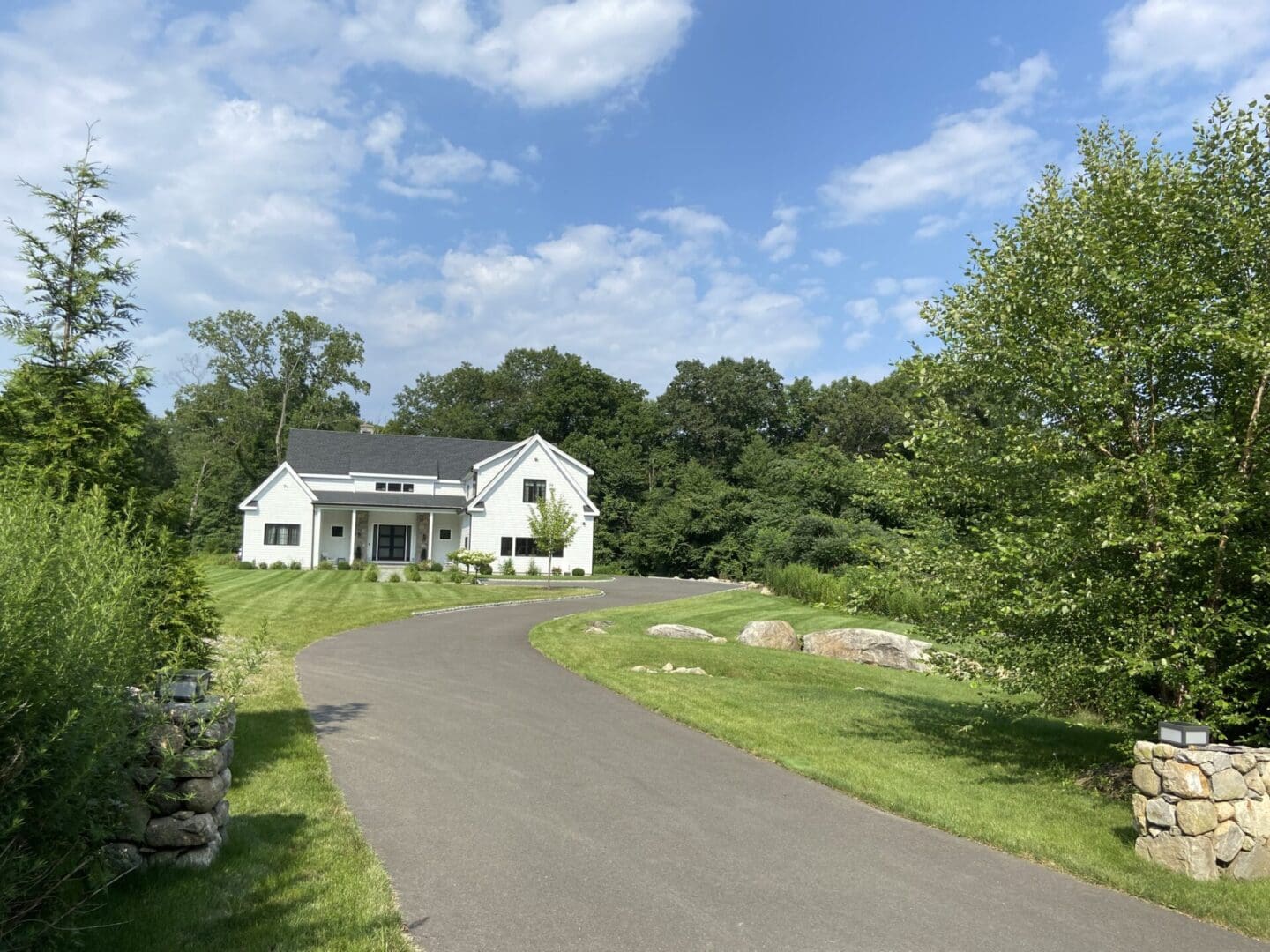 White farmhouse with long driveway.