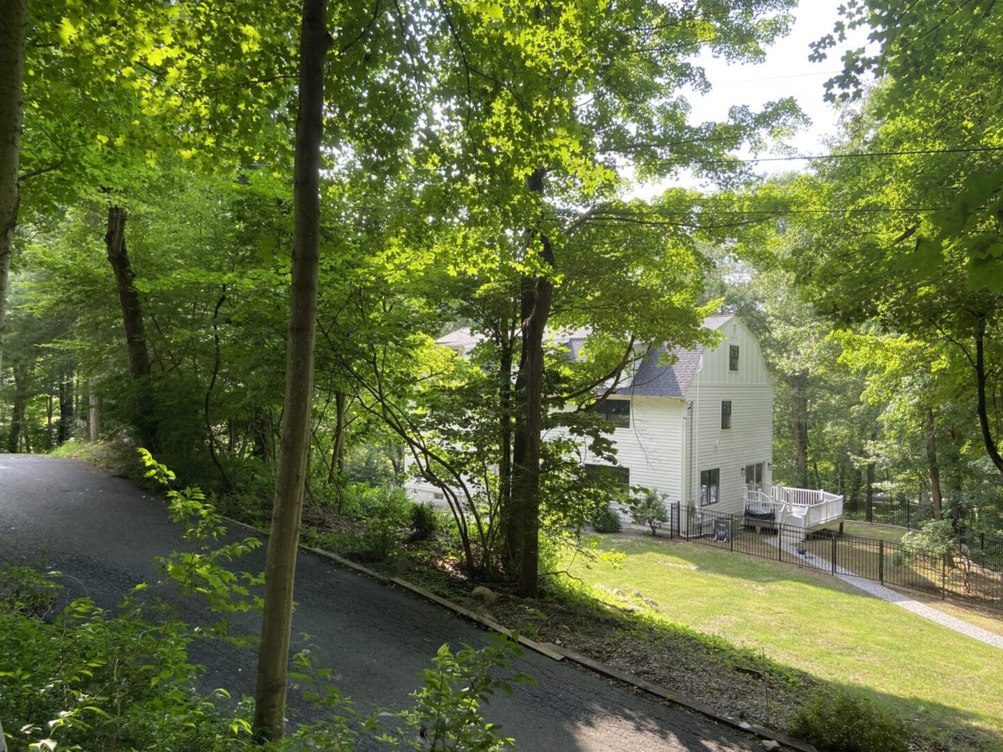 White house with black fence on a hill.