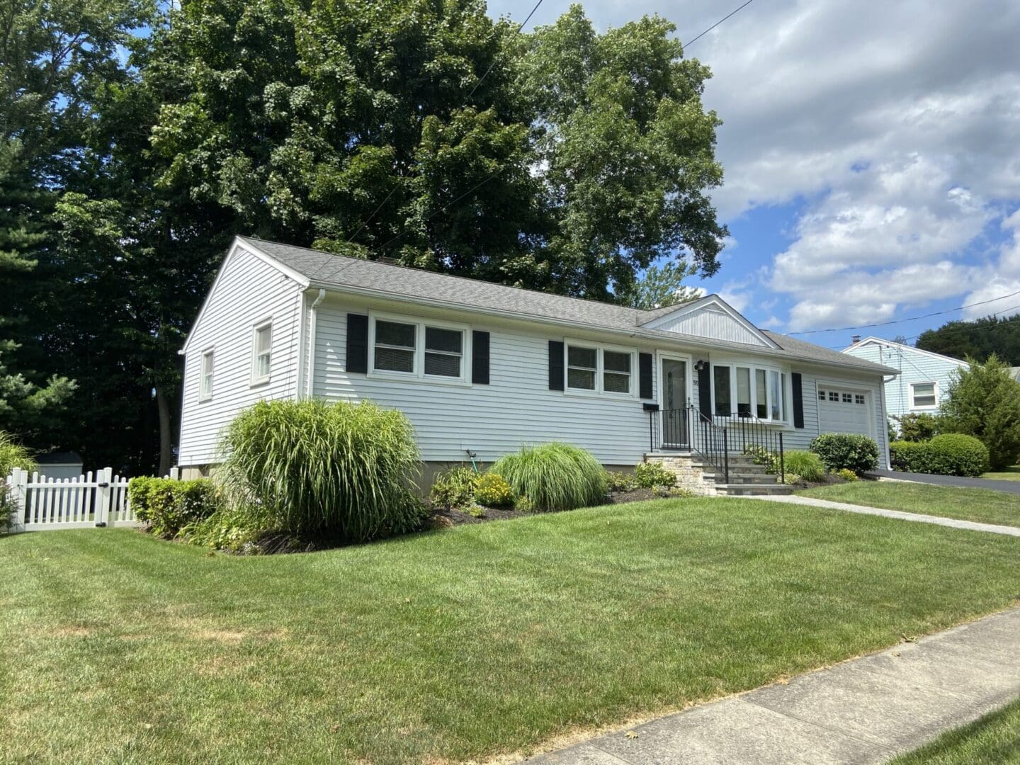 White suburban house with green lawn.