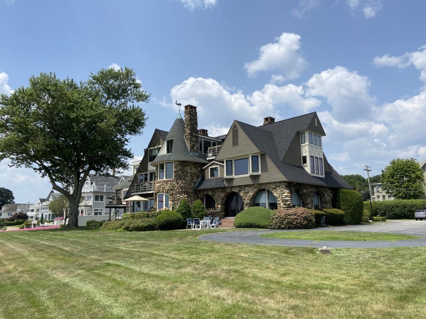 Stone mansion with a turret and yard.