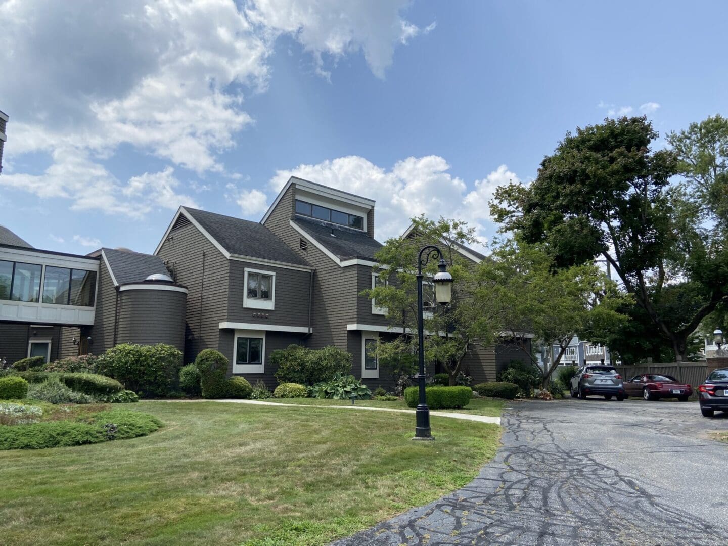 Brown building with green lawn and cars.