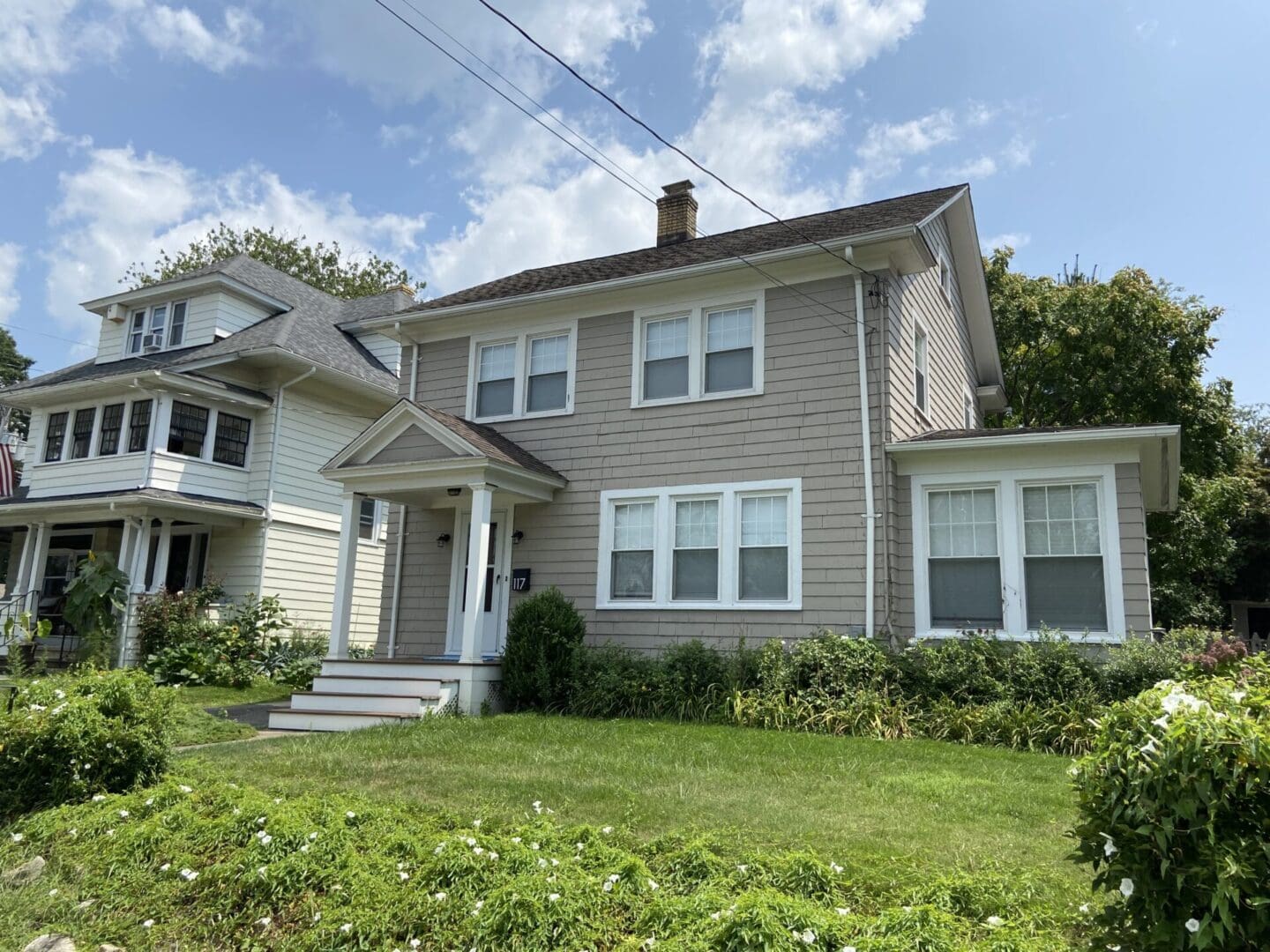 A gray suburban house with a porch.