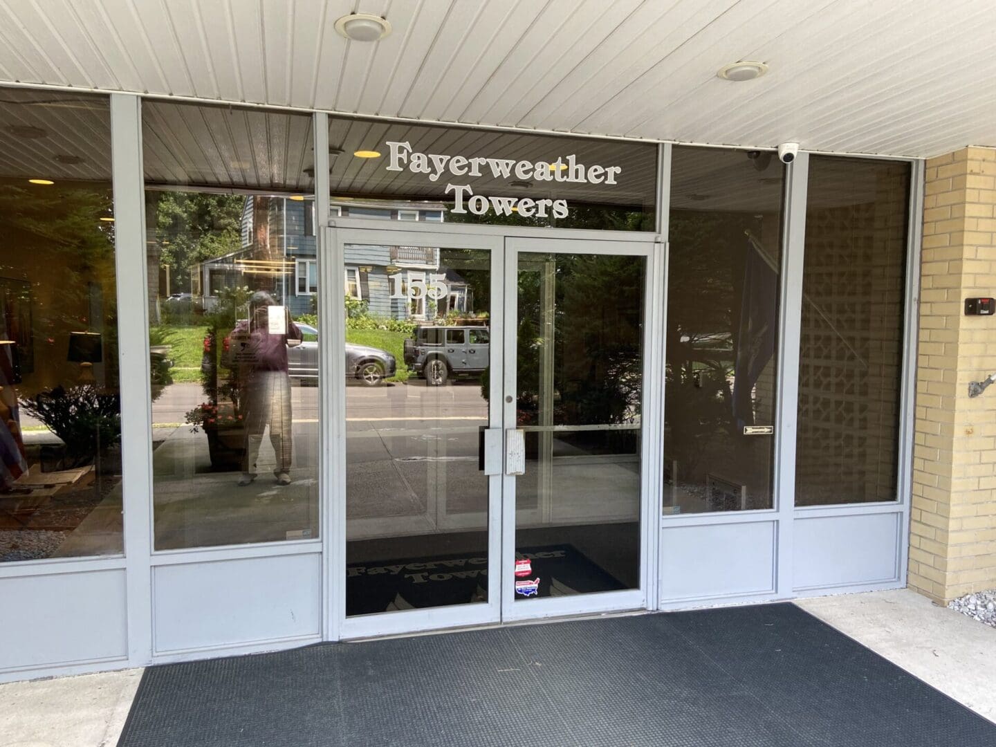 Glass doors with "Fayerweather Towers" sign.