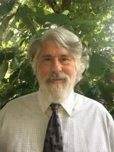 Man with gray hair and beard wearing a tie