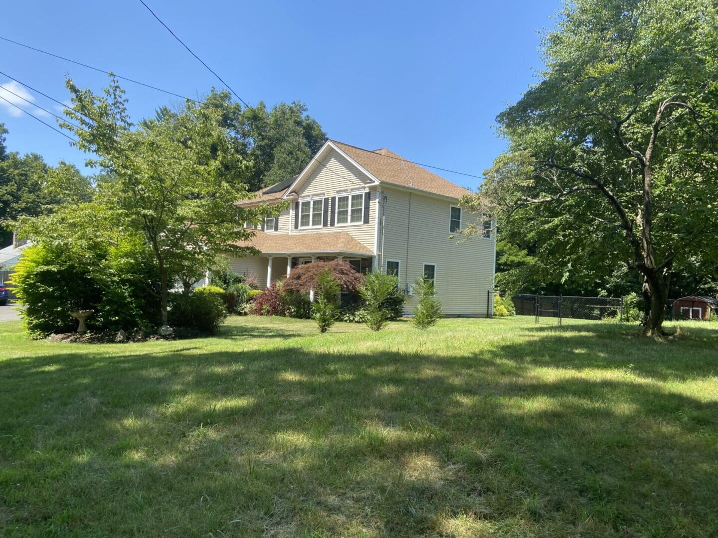 A beige suburban house with a lawn.