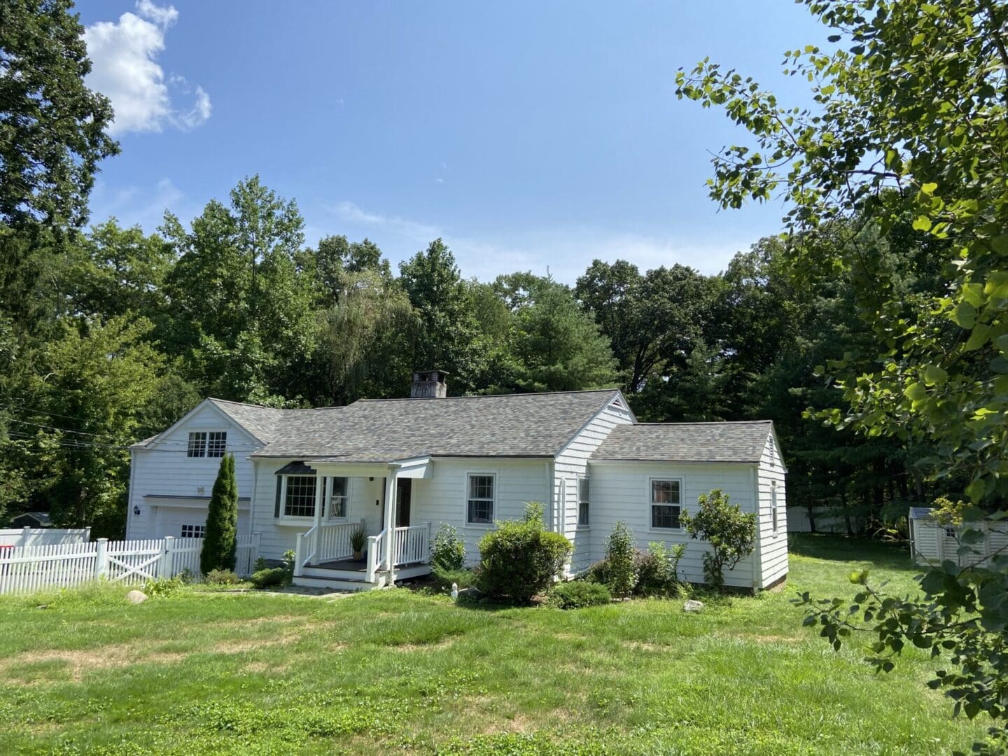 White suburban house with green lawn.