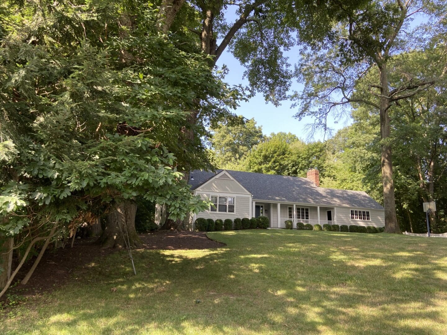 A white house with a green lawn.