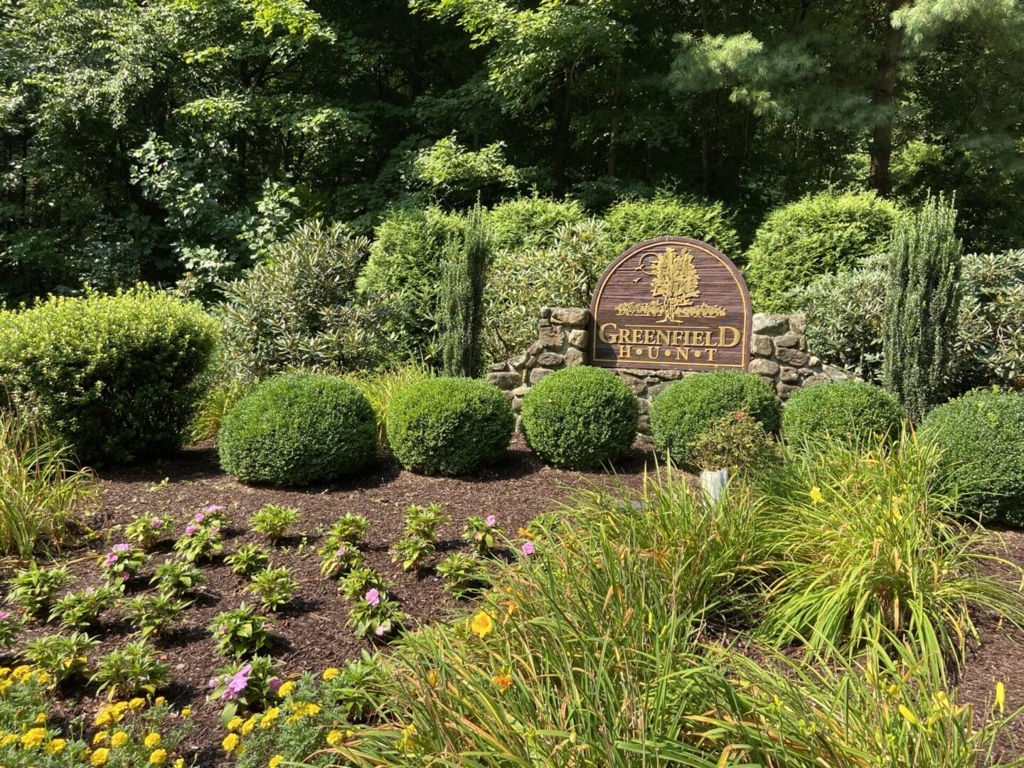 Greenfield Hunt entrance sign with flowers.