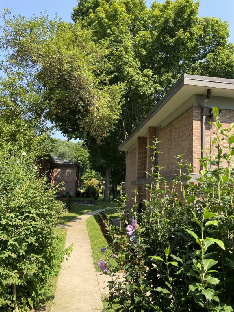 Brick building with a pathway and flowers.