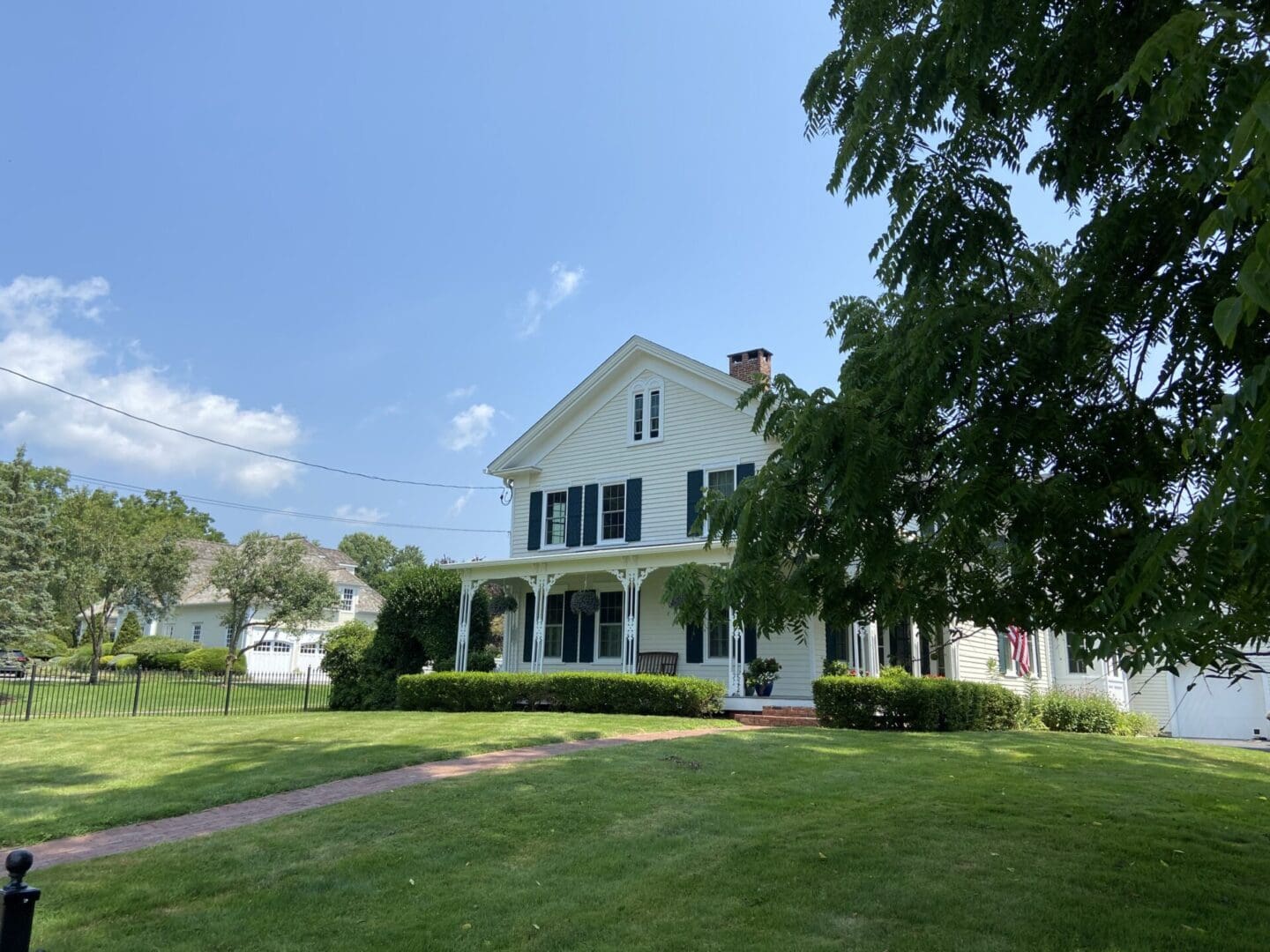 White house with green shutters and porch.