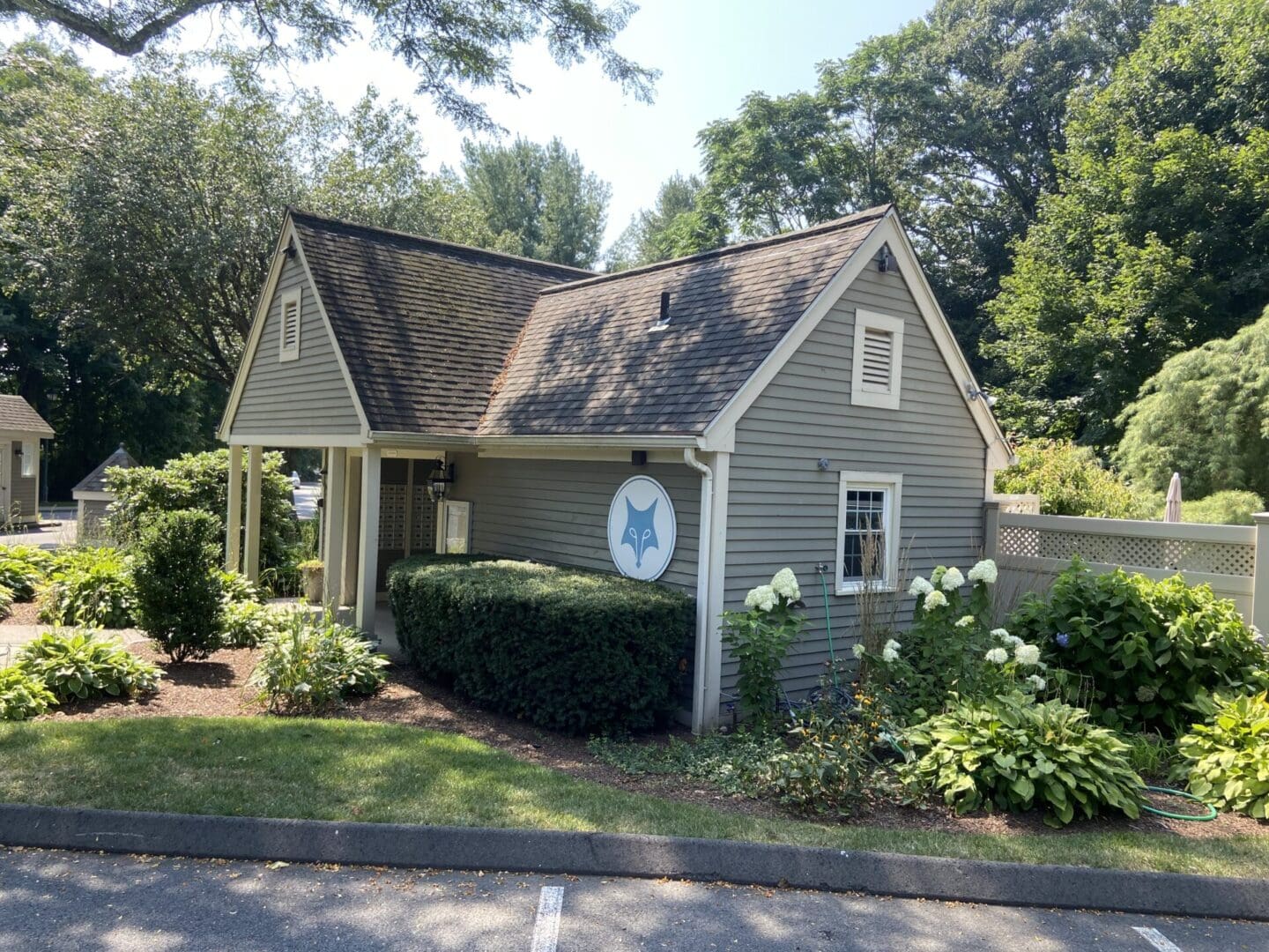 Gray building with fox logo, landscaping.