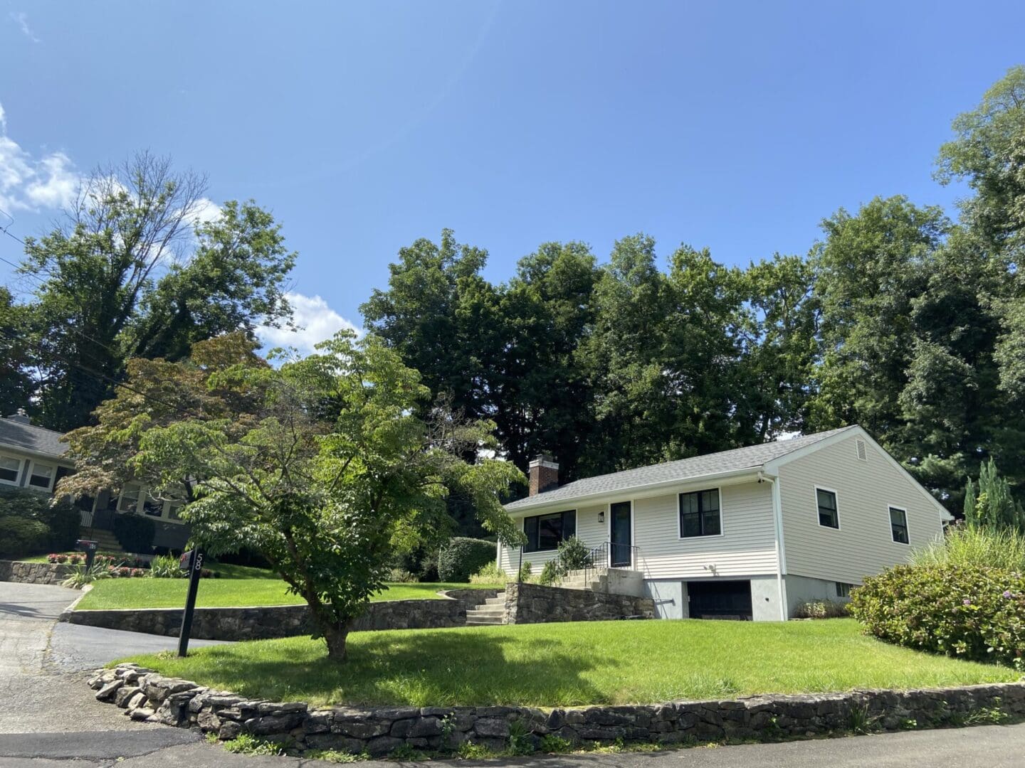 White suburban house with green lawn.