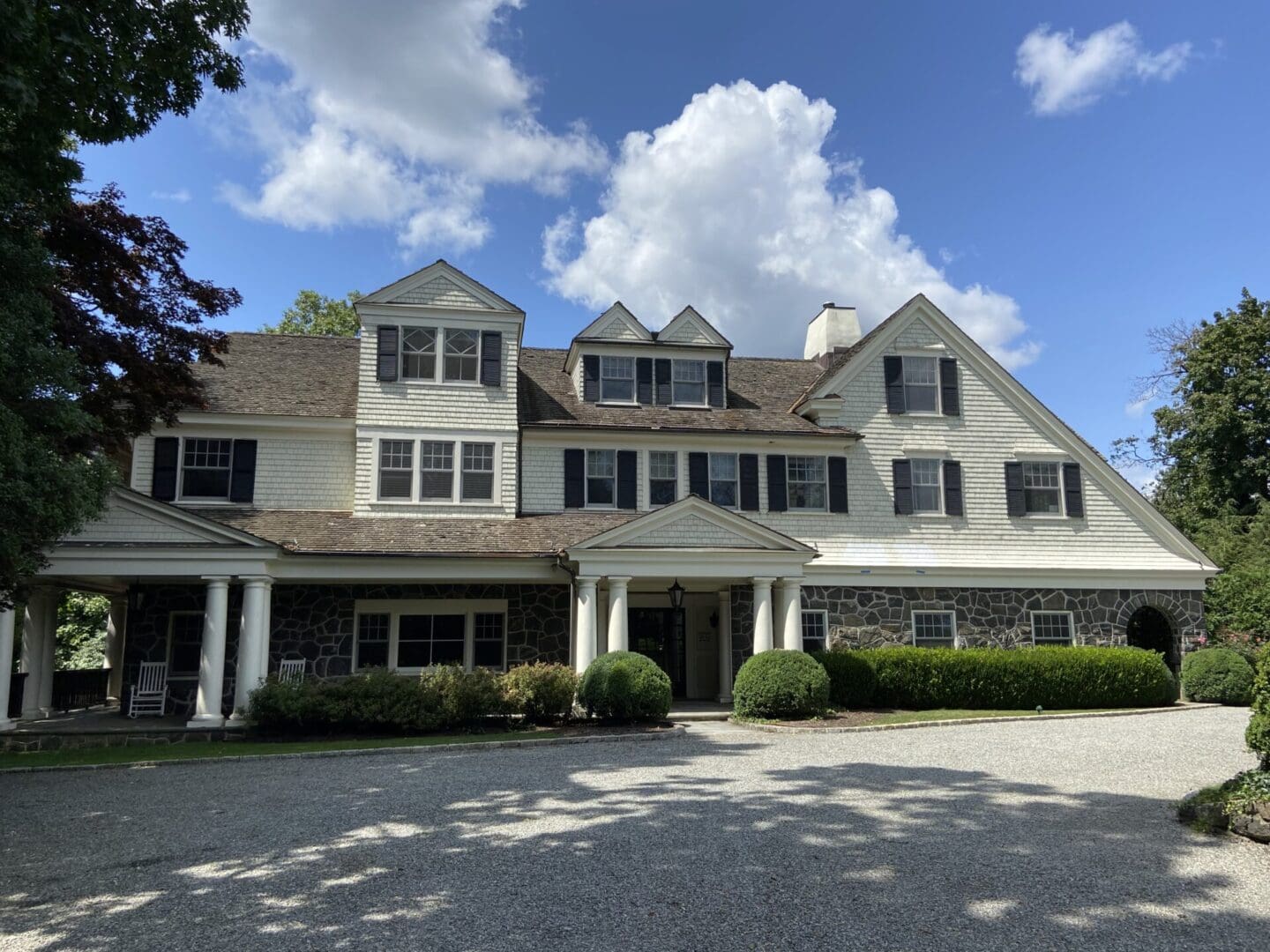 White suburban house with stone foundation.