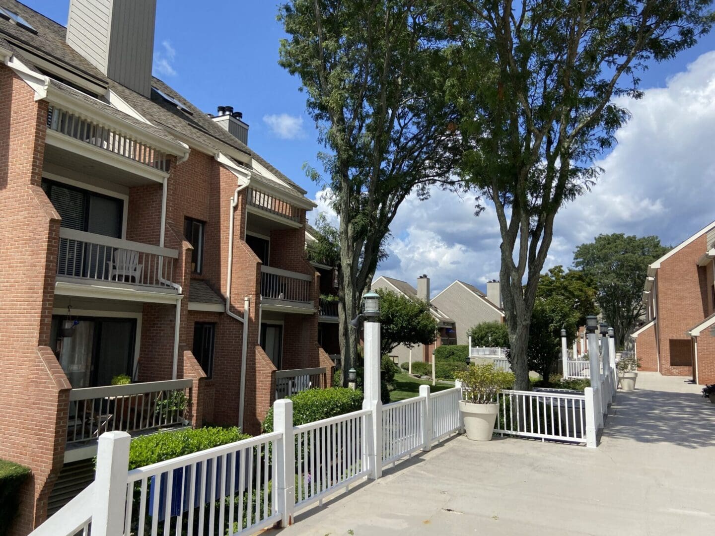 Brick townhouse complex with white fence.