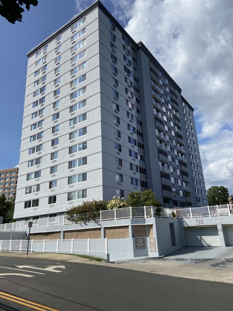 Gray apartment building with white fence.