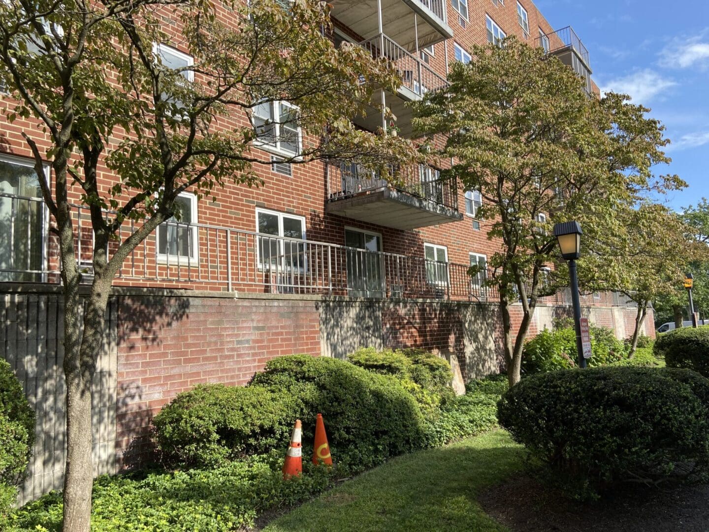 Brick building with balconies and trees.