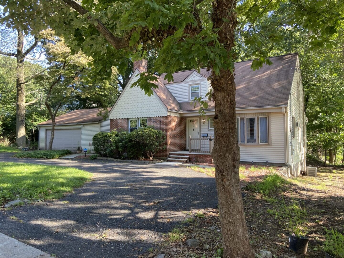 Suburban home with driveway and trees.