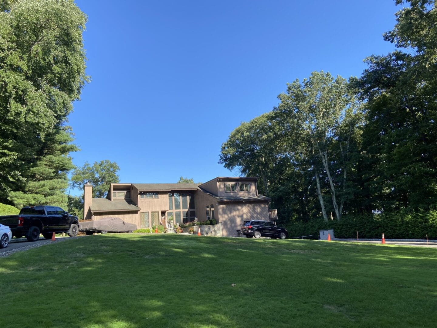 A brown house with a green lawn.