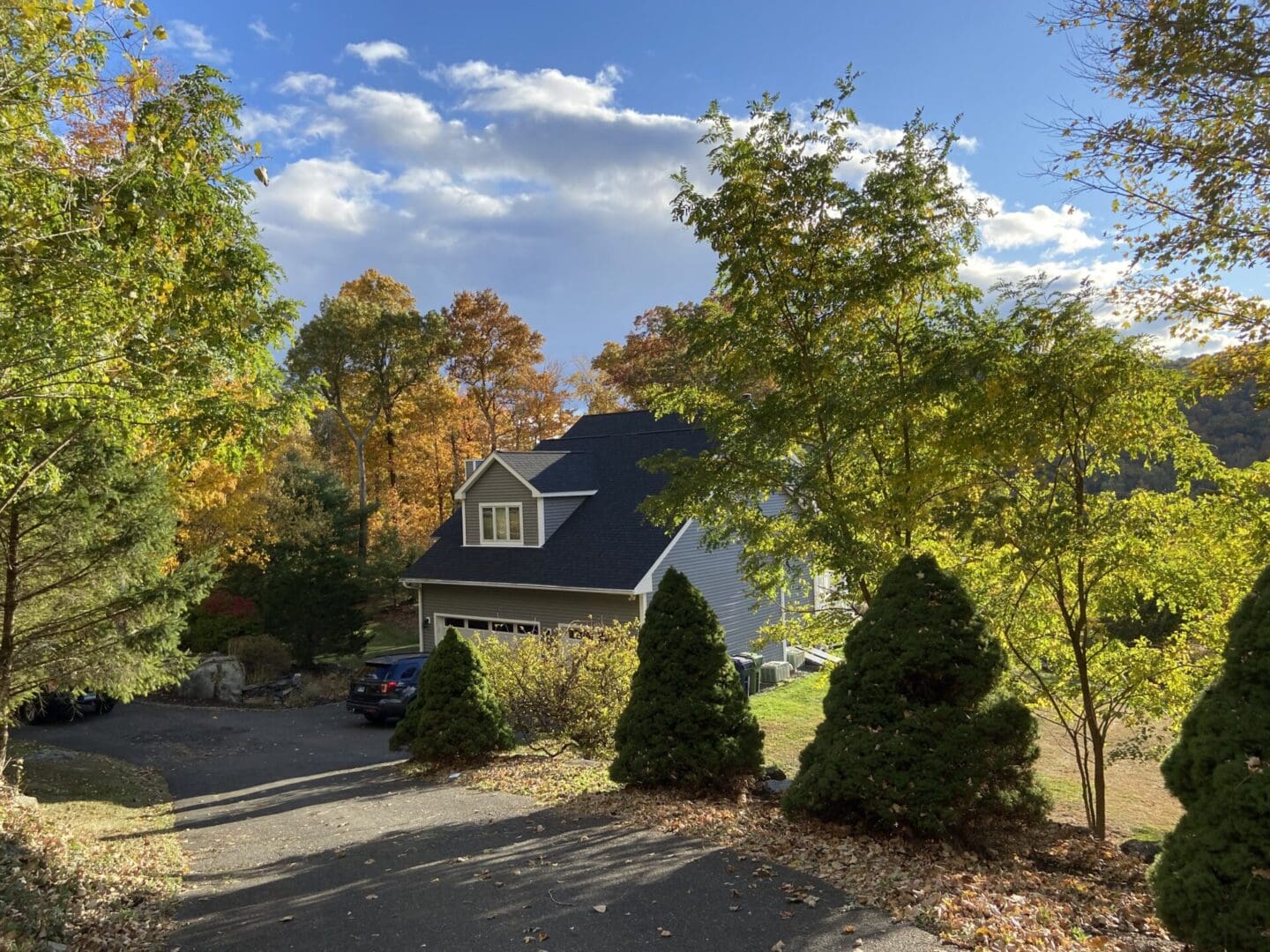 Autumn house with driveway and trees.