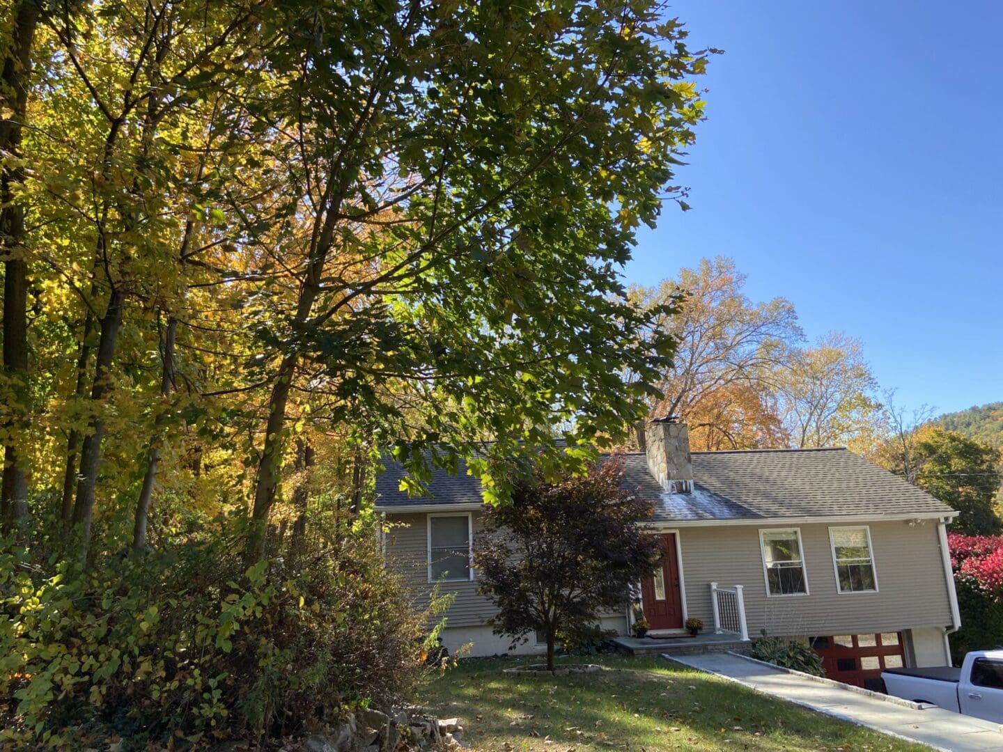 House with fall foliage and blue sky.