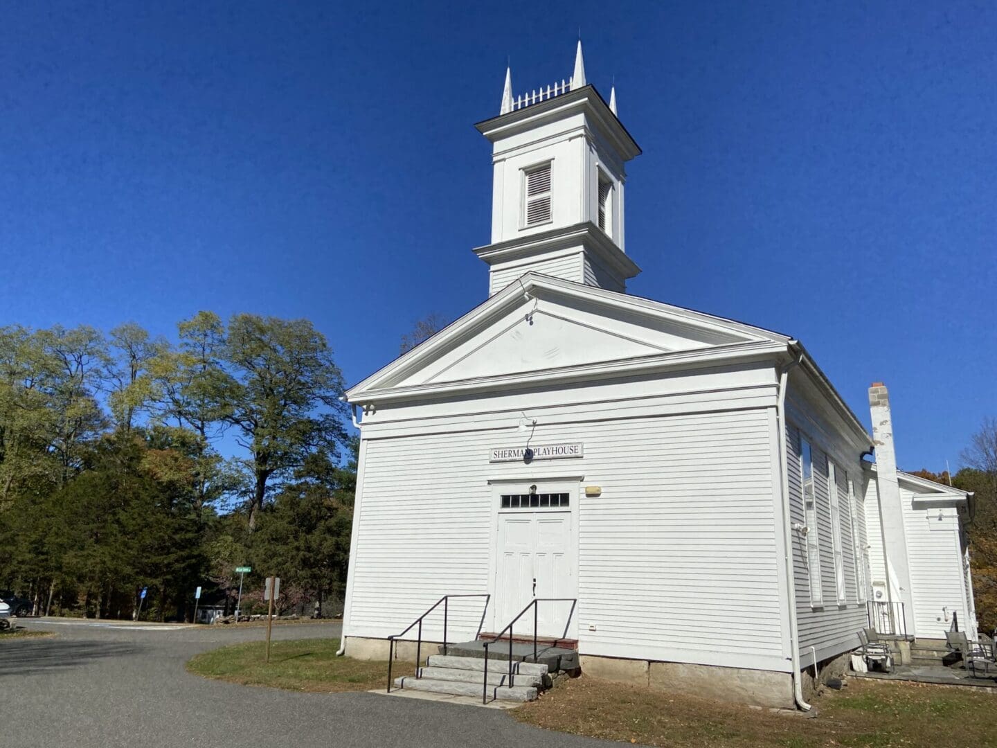 White church with a steeple and sign.