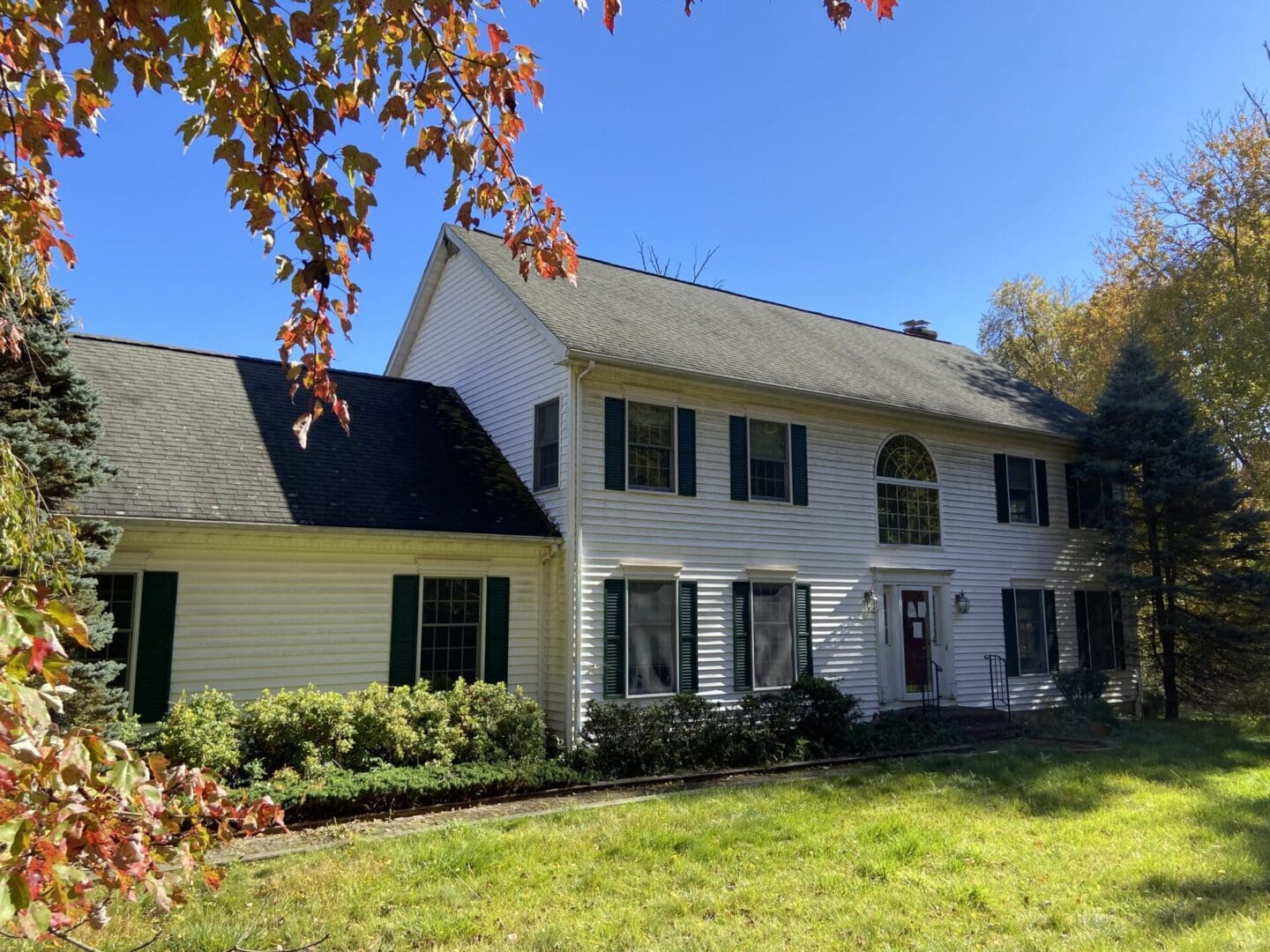 White two-story house with green shutters.