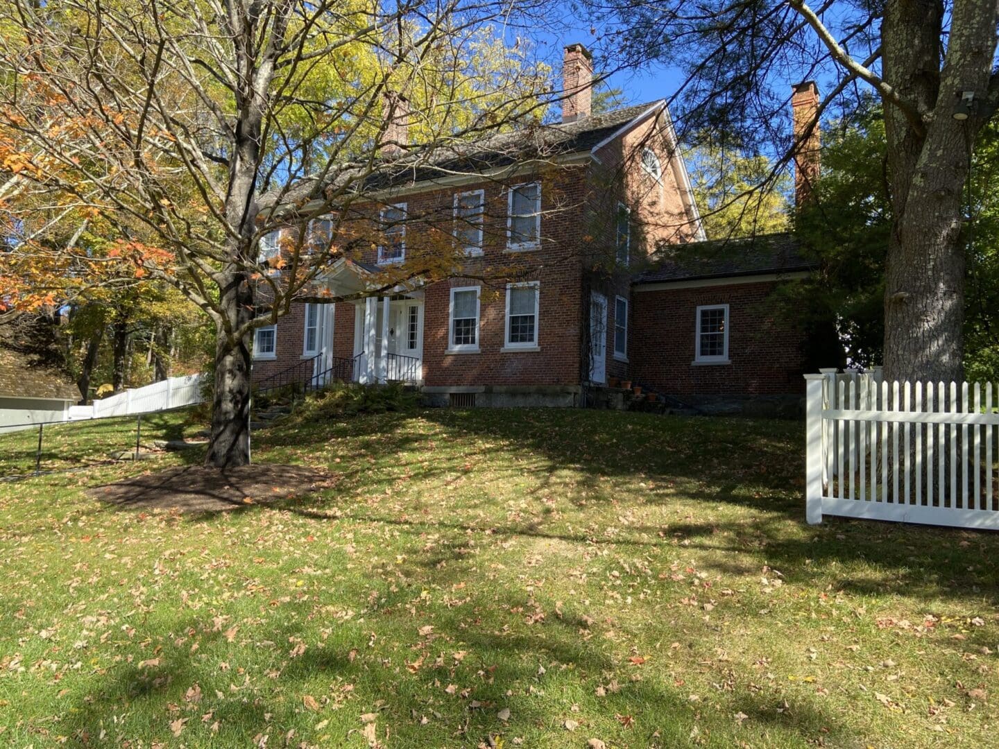 Brick colonial house, autumn leaves.