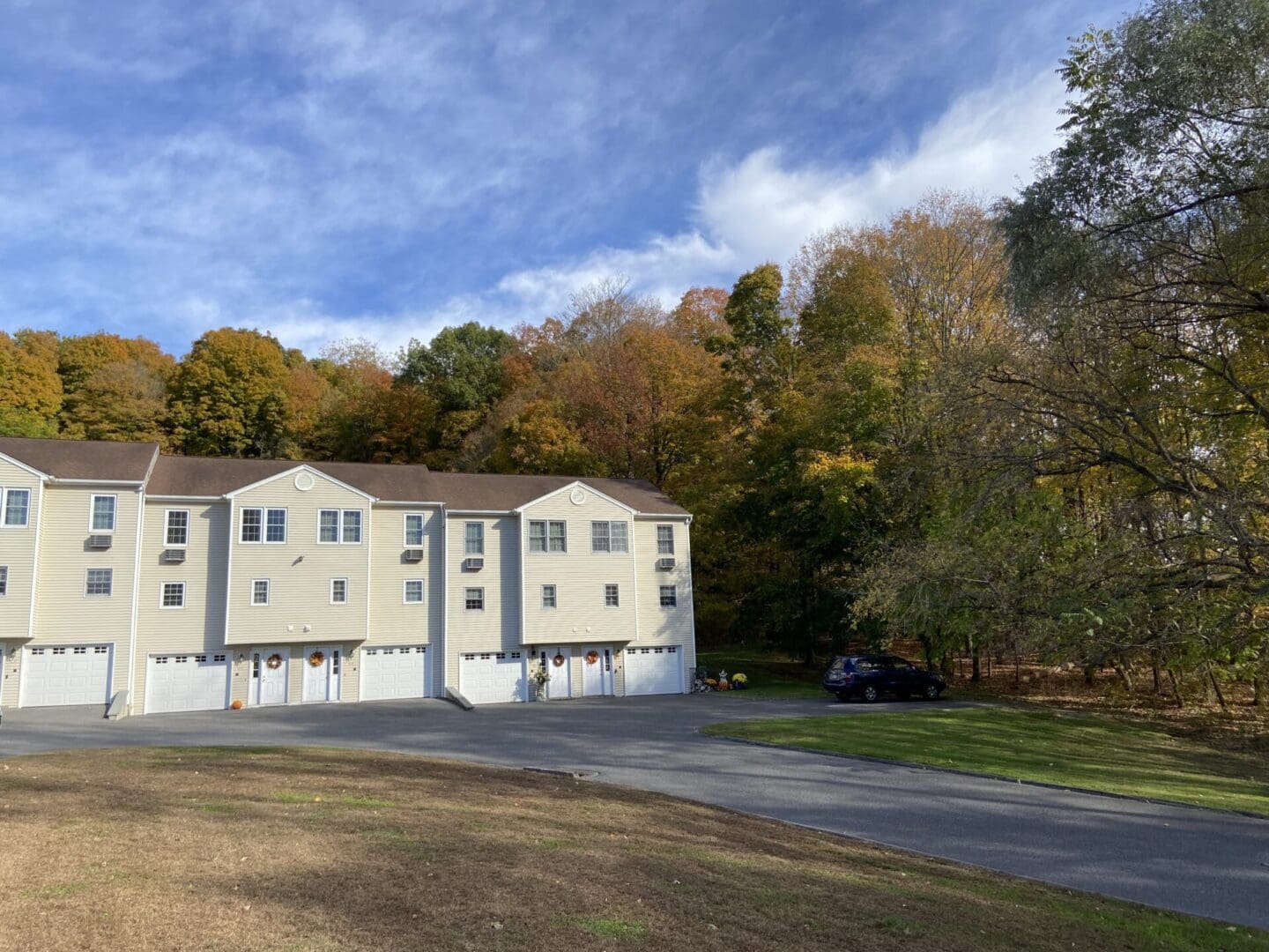 Townhouses with autumn foliage backdrop.