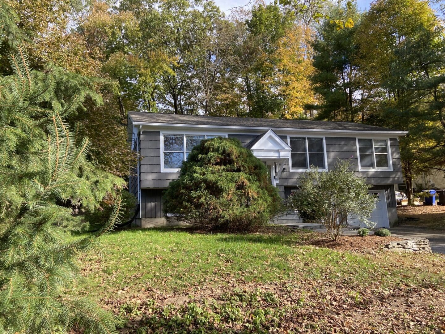 Gray house with trees and a lawn.