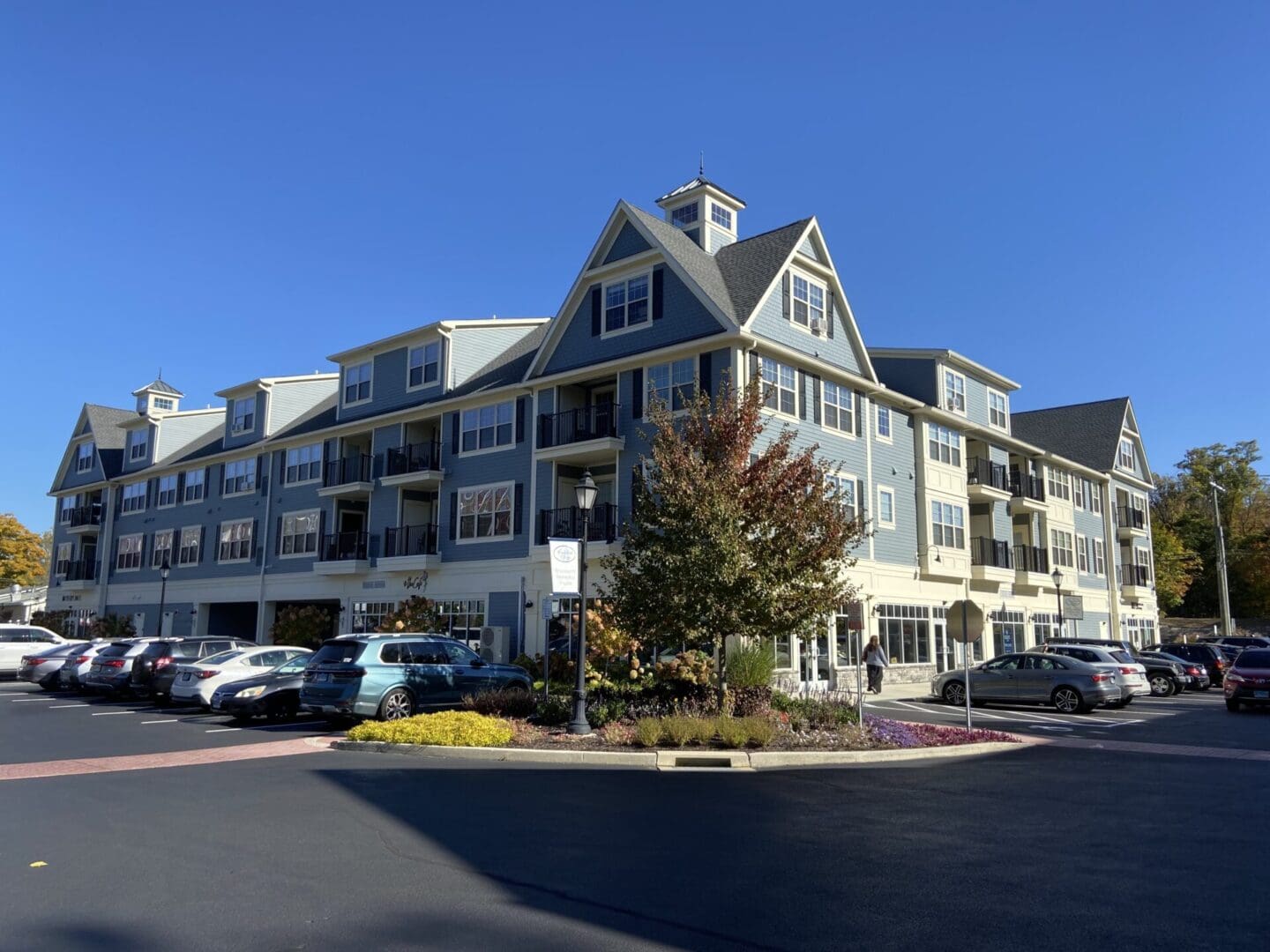 Blue apartment building with parking lot.